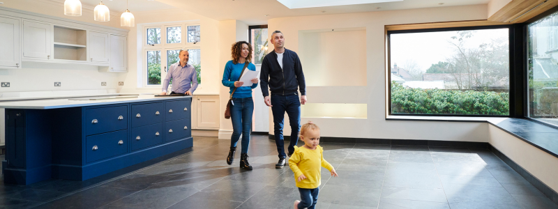 Family viewing an open house with real estate agent in kitchen
