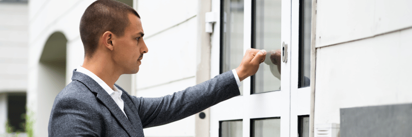 male real estate agent knocking on front door of house