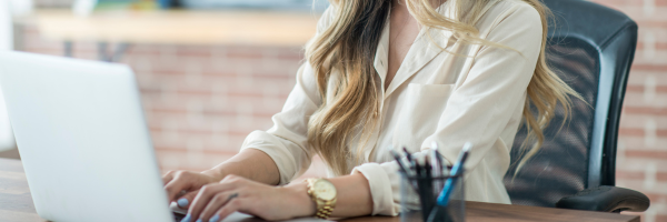 Female real estate agent typing on computer
