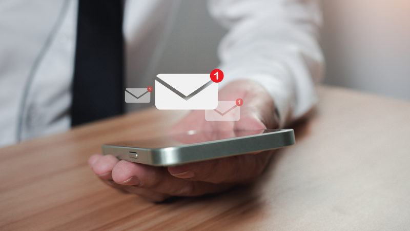 Male real estate agent looking on his phone and receiving emails