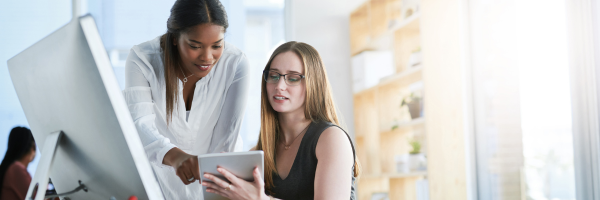 Two female real estate agents discussing what type of email to send